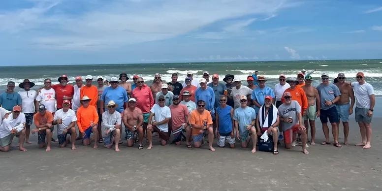 Sigma Nu brothers group photo on the beach at Litchfield