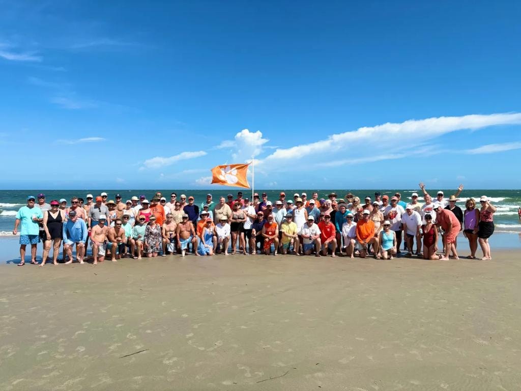 Litchfield 2026 — large group gathered on beach with flag